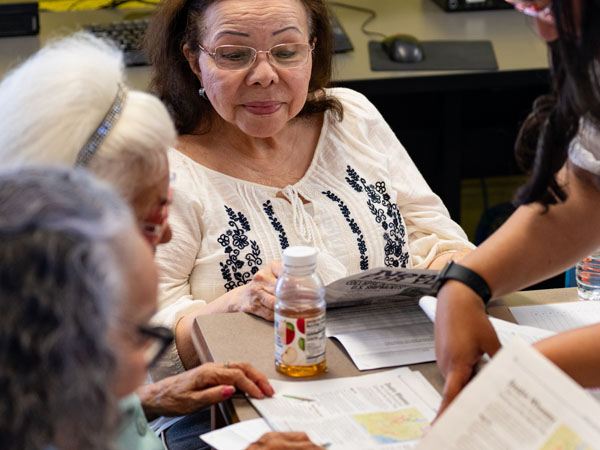 Teacher guides a group of adults in an ESL vocabulary lesson.