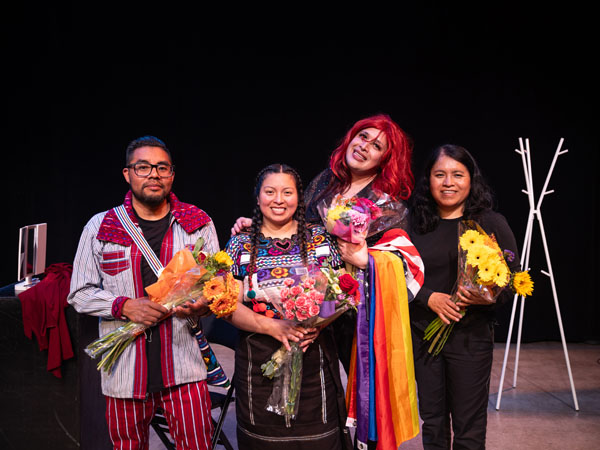 Four performers smile after their show. 