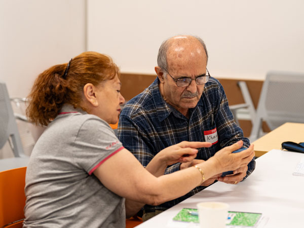 woman helping man with tech device