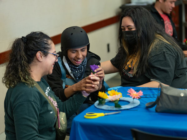 Three people at a table making a craft