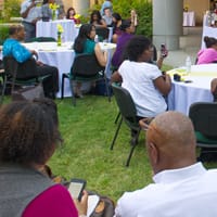 Crowd view of people at the 2017 Juneteenth event. Many sitting at tables covered in white tablecloths.