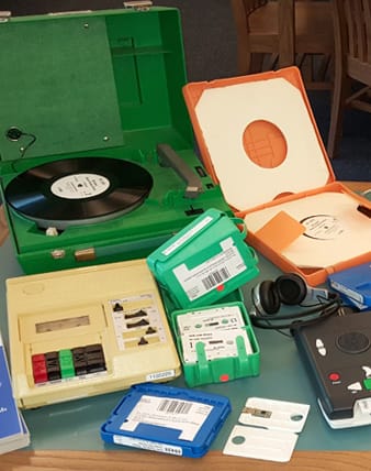 Photo of a record player, a cassette player, and media.