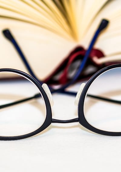 Photo of a pair of reading glasses and a book