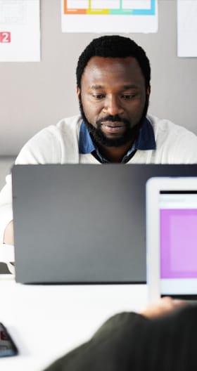 An African-American man working on a computer.
