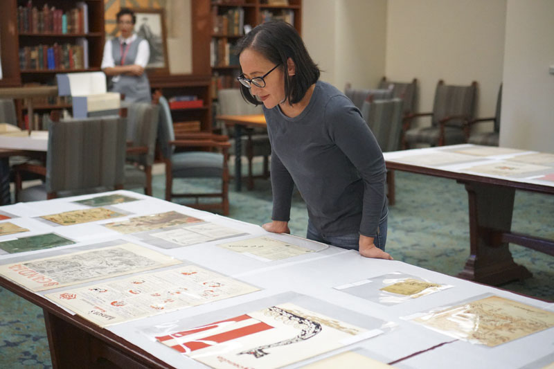 Woman looking at a large Library table display of document and books. Photo courtesy of the Los Angeles Public Library.