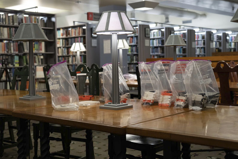 Completed Face shields lined up on a table in a library’s reading room. Photo courtesy of the Los Angeles Public Library.