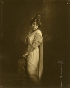 Black and white portrait of an Asian woman with an elaborate hairstyle and white dress.