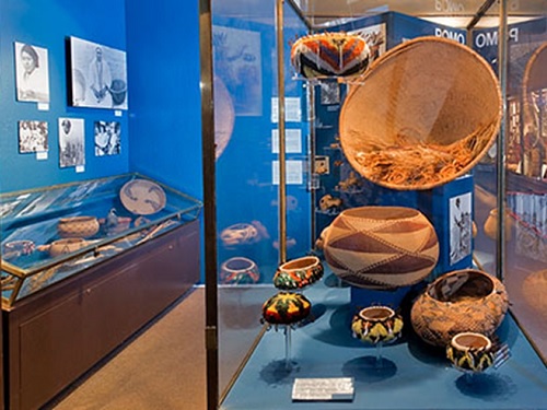 Native American baskets on display in a case in a museum setting.
